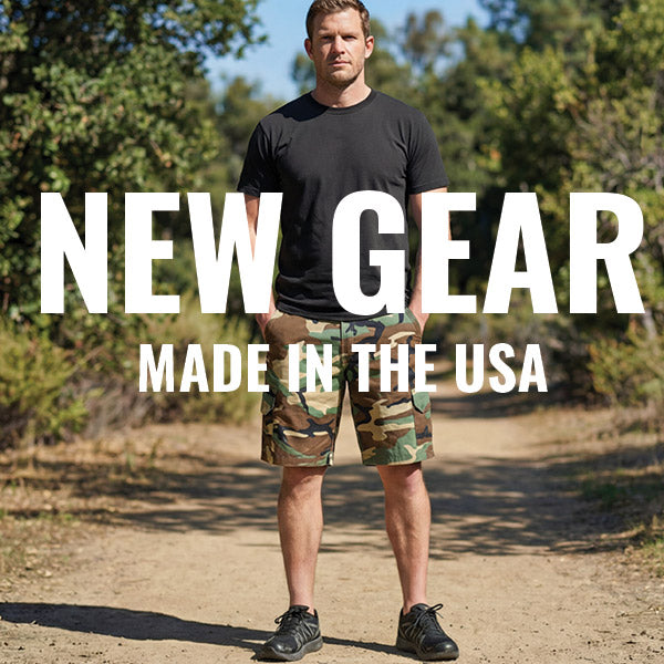 Man wearing a black t-shirt and camouflage shorts standing outdoors with 'NEW GEAR MADE IN THE USA' text overlay.
